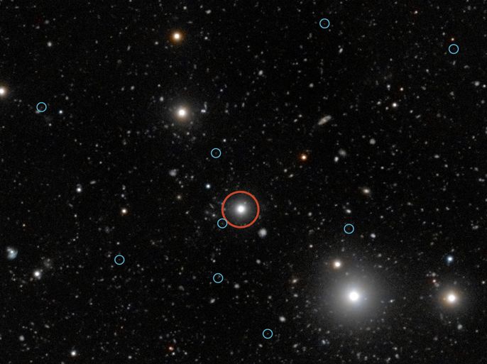 epa03304065 Handout picture provided by the Austral European Observatory (ESO), on 11 July 2012, which shows the region surrounding the quasar HE0109-3518 ( marked with a red circle). The quasar is near the center of the image and its energy radiation causes the dark galaxies to shine, helping astronomers to understand the dark early stages of galaxy formation. The faint glow of twelve dark galaxies is marked with blue circles. EPA