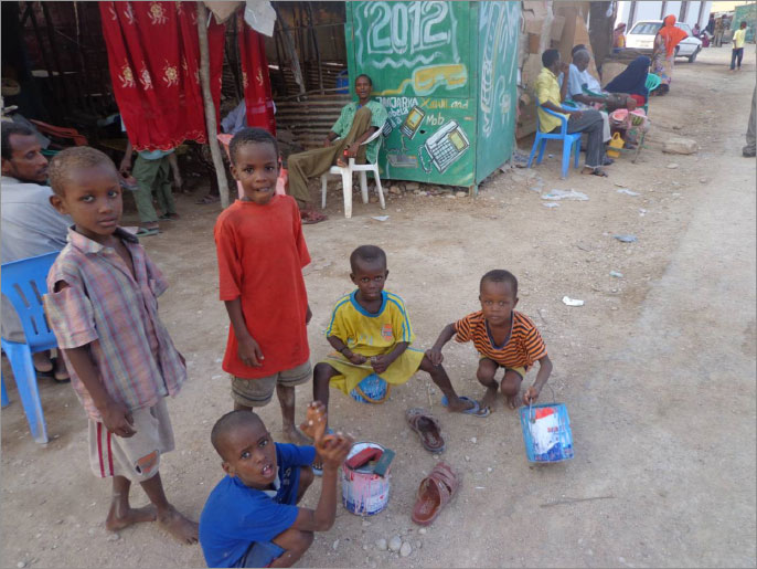 أطفال صغار يعملون في مسح الأحذية بالمقاهي القريبة من مخيم بولو أيلي(الجزيرة)