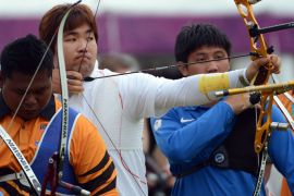 Im Dong-Hyun of South Korea (C) prepares to shoot during the ranking round of the men's archery individual event at the Lord's Cricket Ground in London on July 27, 2012 during the London 2012 Olympic Games. AFP PHOTO / TOSHIFUMI KITAMURA