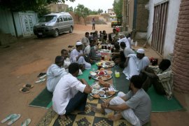 ASH2340 - Khartoum, -, SUDAN : Sudanese break their fast as they sit along a street in West Jarif, some 7 kilometers east of the capital Khartoum, on July 22, 2012. Muslims fasting in the month of Ramadan must abstain from food, drink and sex from dawn until sunset, when they break the fast with the meal known as Iftar. AFP PHOTO / ASHRAF SHAZLY