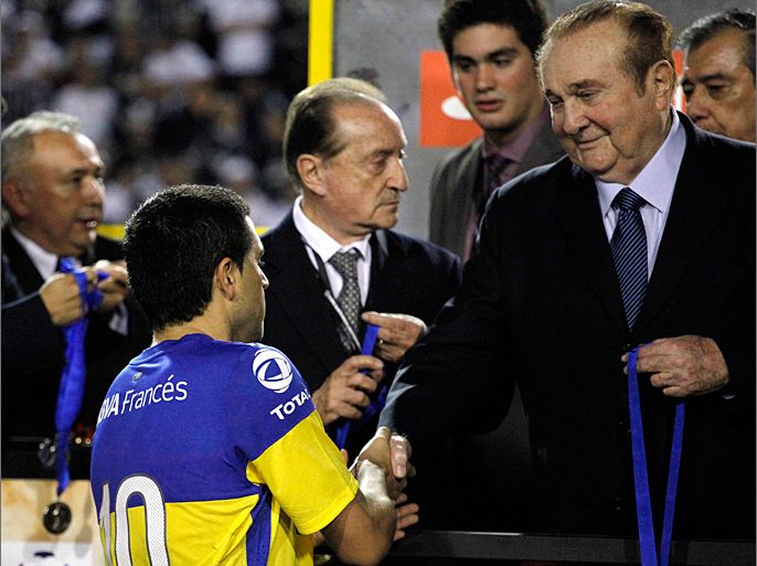 Juan Roman Riquelme of Argentina's Boca Juniors receives his second-place medal from CONMEBOL President Nicolas Leoz after they lost to Brazil's Corinthians in the second leg final soccer match of the Copa Libertadores, in Sao Paulo, July 4, 2012. REUTERS/Nacho Doce (BRAZIL - Tags: SPORT SOCCER)