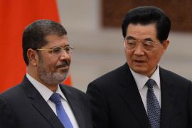 MRR057 - Beijing, -, CHINA : Chinese President Hu Jintao (R) and Egyptian President Mohamed Morsi attend a welcoming ceremony at the Great Hall of the People in Beijing on August 28, 2012. Egypt's president met his Chinese counterpart in Beijing on August 28, seeking in his first state visit outside the Arab world to win badly needed investment and expand diplomatic ties. AFP PHOTO / Mark RALSTON