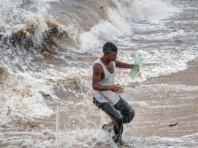 CUBA : A man runs away from the waves in Gibara, Holguin province, Cuba on August 25, 2012, during tropical storm Isaac.