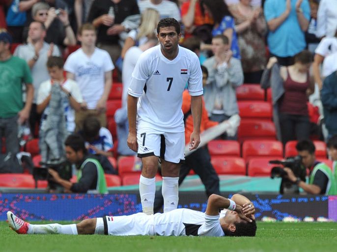 Egypt's defender Fathi Ahmed (C) consoles a team mate after losing 3-0 in the London 2012 Olympic men's football quarter final match between Japan and Egypt at Old Trafford in Manchester, north-west England, on August 4, 2012. AFP PHOTO/PAUL ELLIS