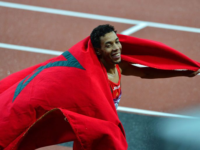 Morocco's Abdalaati Iguider celebrates with his national flag at the end of the men's 1500m final at the athletics event during the London 2012 Olympic Games on August 7, 2012 in London. Iguider won the bronze medal. AFP PHOTO / GABRIEL BOUYS