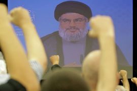 Lebanese Shiite men raise their fists up as they listen to a speech via videolink by Hezbollah leader Hassan Nasrallah marking Al-Quds (Jerusalem) Day in the southern suburbs of Beirut on August 17, 2012 . Nasrallah warned that his Lebanese Shiite militia would make lives of Israelis "a living hell" if it is attacked. AFP PHOTO/ANWAR AMRO