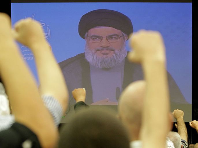Lebanese Shiite men raise their fists up as they listen to a speech via videolink by Hezbollah leader Hassan Nasrallah marking Al-Quds (Jerusalem) Day in the southern suburbs of Beirut on August 17, 2012 . Nasrallah warned that his Lebanese Shiite militia would make lives of Israelis "a living hell" if it is attacked. AFP PHOTO/ANWAR AMRO