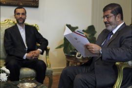 r : Egypt's President Mohamed Mursi reads a letter from Iranian President Mahmoud Ahmadinejad as he attends a meeting with Iranian Executive Vice President Hamid Baghai at the presidential palace in Cairo, August 8, 2012. Mursi was invited to a Non-Aligned Movement (NAM) summit in Tehran, held from August 30-31. REUTERS/Amr Abdallah Dalsh (EGYPT - Tags: POLITICS)