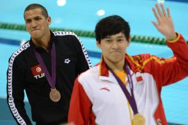 China's Sun Yang (R) poses on the podium with the gold medal next to bronze medalistTunisia's Oussama Mellouli after winning the men's 1500m freestyle final during the swimming event at the London 2012 Olympic Games on August 4, 2012 in London. AFP PHOTO / CHRISTOPHE SIMON