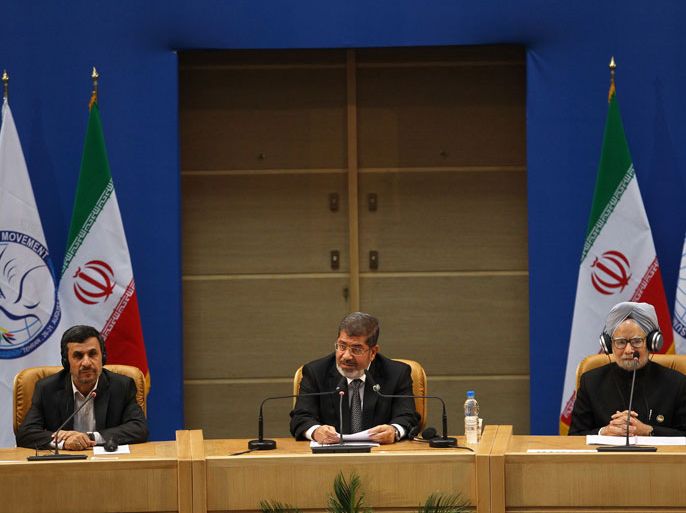 -, IRAN : Iranian President Mahmoud Ahmadinejad (L) and Indian Prime Minister Manmohan Singh (R) listen to a speech by Egyptian President Mohamed Morsi (C) at the Non-Alligned Movement (NAM) summit in Tehran on August 30, 2012. AFP PHOTO/MEHR NEWS/RAOUF MOHSENI
