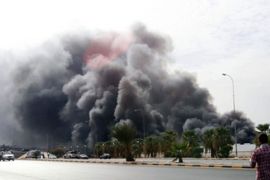 A genreal view shows, smoke rising from a warehouse, at naval base, in Tripoli, Libya, 24 September 2011. According to media sources, the warehouse for miilitary vehicle was set on fire by a series of explosions. The cause remains unknown. EPA/MOHAMED MESSARA