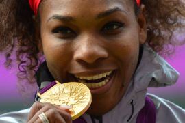 US Serena Williams poses on the podium with her gold medal after defeating Russia's Maria Sharapova in the women's singles gold medal match of the London 2012 Olympic Games, at the All England Tennis Club in Wimbledon, southwest London, on August 4, 2012. AFP PHOTO / LUIS ACOSTA