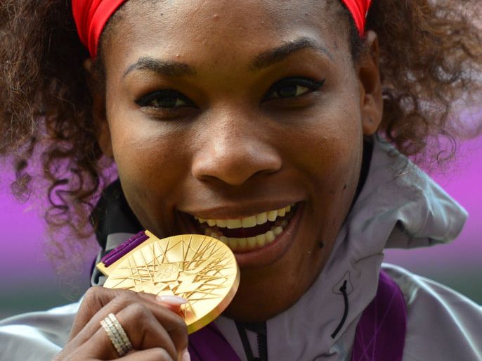 US Serena Williams poses on the podium with her gold medal after defeating Russia's Maria Sharapova in the women's singles gold medal match of the London 2012 Olympic Games, at the All England Tennis Club in Wimbledon, southwest London, on August 4, 2012. AFP PHOTO / LUIS ACOSTA
