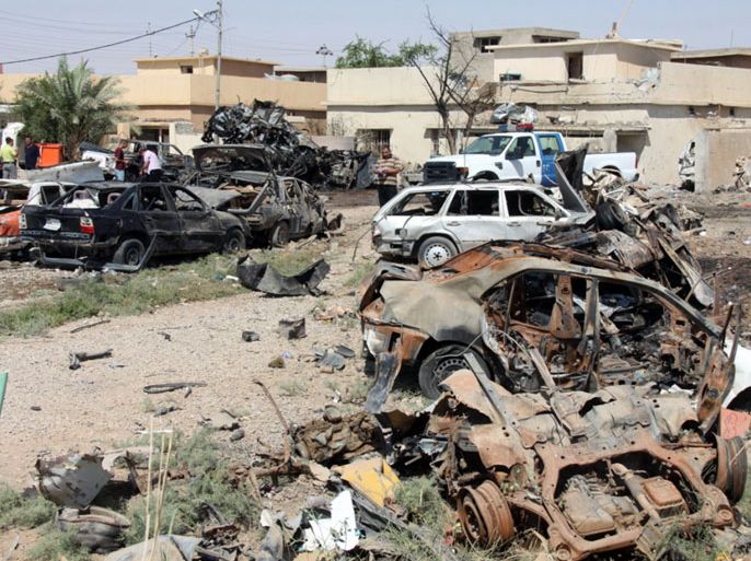 Iraqis inspect the remains of destroyed vehicles in the aftermath of at least four car bombs where were set off across the northern Iraqi city of Kirkuk on August 16, 2012. A wave of attacks across Iraq today killed at least eight people