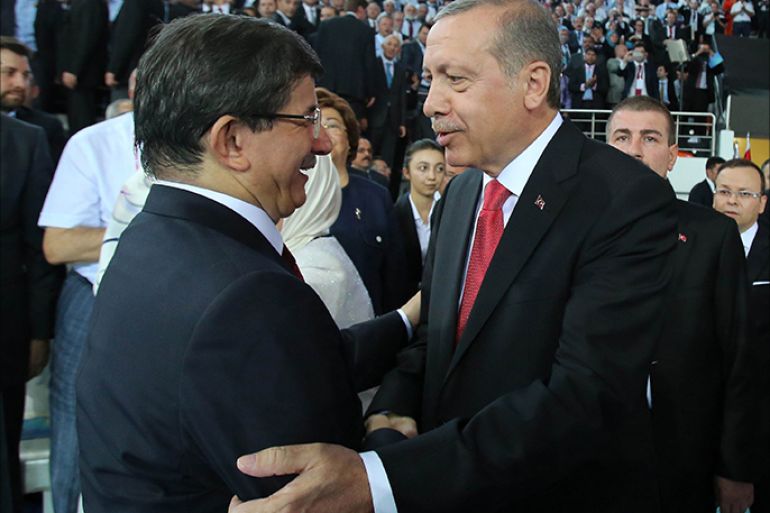 Turkish Prime Minister and head of Turkey’s ruling Justice and Development Party (AKP) Recep Tayyip Erdogan (R) shakes hands with Turkish Foreign Minister Ahmet Davutoglu (2nd L) as he arrives on August 27, 2014 for the 2014 AKP Extraordinary Congress at the Ankara Arena Stadium in Ankara