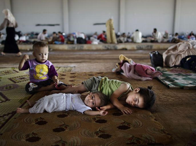 Syrian children, who fled their home with their family due to fighting between the Syrian army and the rebels, lie on the ground, while they and others take refuge at the Bab Al-Salameh border crossing, in hopes of entering one of the refugee camps in Turkey, near the Syrian town of Azaz, Sunday, Aug. 26, 2012. Thousands of Syrians who have been displaced by the country's civil are struggling to find safe shelter while shelling and airstrikes by government forces continue.