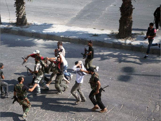 Rebel Free Syrian Army (FSA) fighters drag along a street captured policemen who the FSA allege are “Shabiha” or pro-regime militiamen, on July 31, 2012, as the rebels overran a police station in Aleppo. A watchdog said that rebels killed 40 officers and seized three police stations during the pivotal battle for the commercial capital. AFP PHOTO/EMIN OZMEN/SABAH PRESS