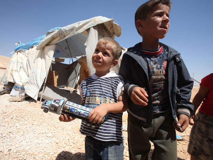 طفل سوري يحمل لعبة في مخيم الزعتري صبيحة أول أيام العيد (الجزيرة نت)