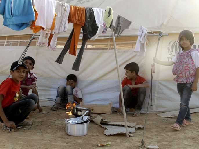 Syrian refugees gather at the Zaatari Camp, Jordan’s first official camp for Syrian refugees fleeing violence in their country, in Mafraq, near the Syrian border, on July 31, 2012.
