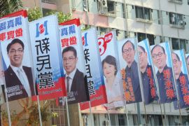 A man stands next to banners promoting candidates running the legislative elections, outside a public housing estate in Hong Kong on September 9, 2012. Hong Kong voters went to the polls in legislative elections seen as a crucial test for the Beijing-backed government, as calls for full democracy grow and disenchantment with Chinese rule surges