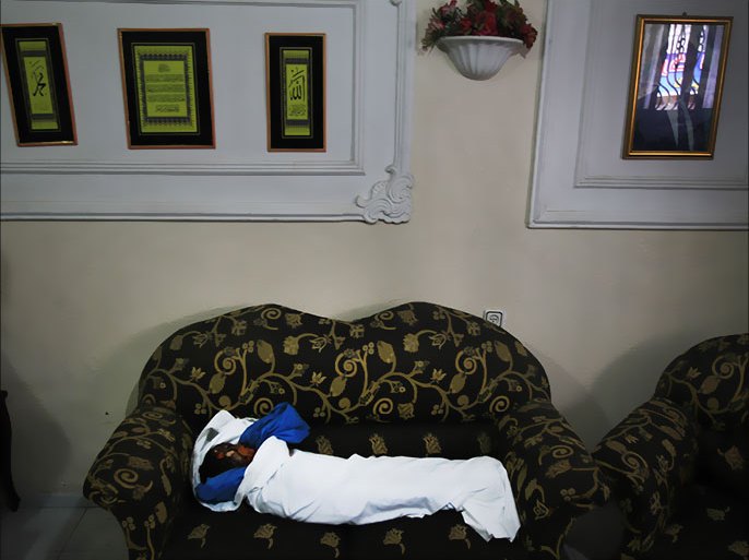 GAZA STRIP, - : The body of three-year-old Fathi Baghdadi, who was killed in an overnight domestic fire, lies on a couch at his home in the Bureij refugee camp, centeral Gaza Strip, on September 26, 2012. The boy was found dead while his sister and father suffered from burns in a fire caused by a candle being used due to lack of electricity in the Gaza Strip, which has been suffering from a chronic energy crisis for years, exacerbated by an Israeli blockade of varying intensity imposed in 2006. AFP PHOTO/MAHMUD HAMS