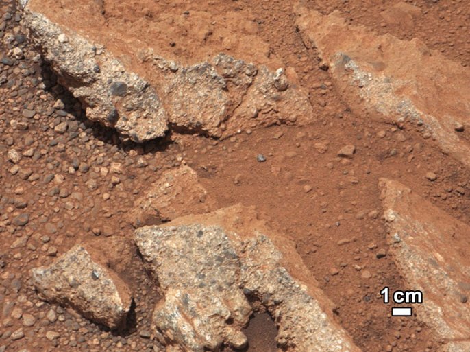 epa03412979 A handout released by NASA shows NASA's Curiosity Rover picture of rock outcrop called Link pops out from a Martian surface that is elsewhere blanketed by reddish-brown dust. The fractured Link outcrop has blocks of exposed, clean surfaces. Rounded gravel fragments, or clasts, up to a couple inches (few centimeters) in size are in a matrix of white material. Many gravel-sized rocks have eroded out of the outcrop onto the surface, particularly in the left portion of the frame. The outcrop characteristics are consistent with a sedimentary conglomerate, or a rock that was formed by the deposition of water and is composed of many smaller rounded rocks cemented together. Water transport is the only process capable of producing the rounded shape of clasts of this size. The Link outcrop was imaged with the 100-millimeter Mast Camera on 02 September 2012, which was the 27th sol, or Martian day of operations. EPA/NASA/JPL-Caltech/MSSS HANDOUT Mandatory Credit: NASA/JPL-Caltech/MSSS HANDOUT EDITORIAL USE ONLY
