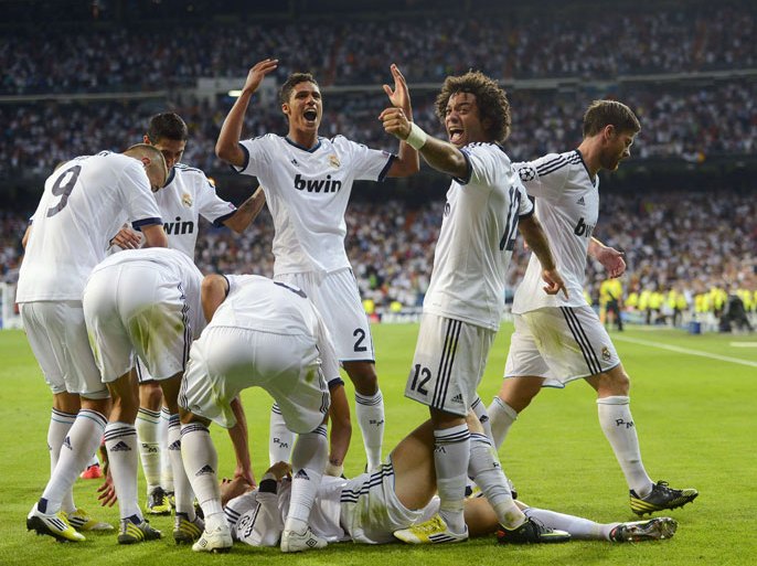 SPAIN : Real Madrid's Portuguese forward Cristiano Ronaldo (on the ground) celebrates with teammates after scoring during the UEFA Champions League football match Real Madrid against Manchester City at the Santiago Bernabeu stadium in Madrid on September 18, 2012. AFP PHOTO/ PIERRE-PHILIPPE MARCOU
