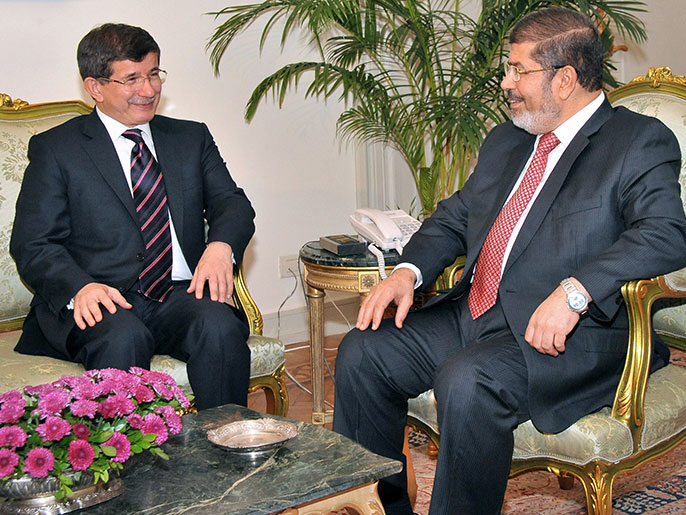 أوغلو (يسار) خلال استقباله من قبل الرئيس محمد مرسي (الفرنسية)