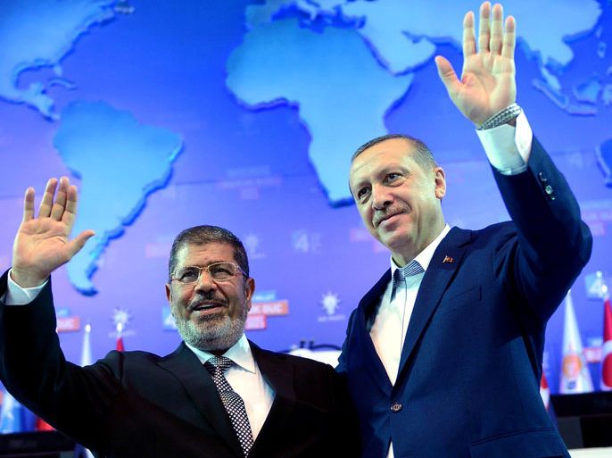 ADM010 - Ankara, Ankara, TURKEY : This hand out picture release by Turkish Prime minister's press office shows Turkey's Prime Minister and leader of the ruling Justice and Development Party (AKP) Recep Tayyip Erdogan (R) and his guest, Egypt's President Mohamed Morsi , greeting the audience during an AKP congress in Ankara on September 30, 2012. AFP PHOTO / TURKISH PRIME MINISTER OFFICE / KAYHAN OZER