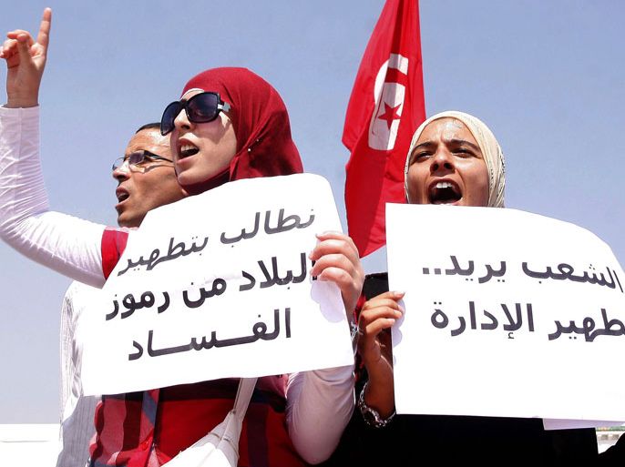 Tunisian women shout slogans while holding signs demanding the "cleansing" of Tunisia at the Kasbah, the site of government headquarters, in Tunis on September 7, 2012.