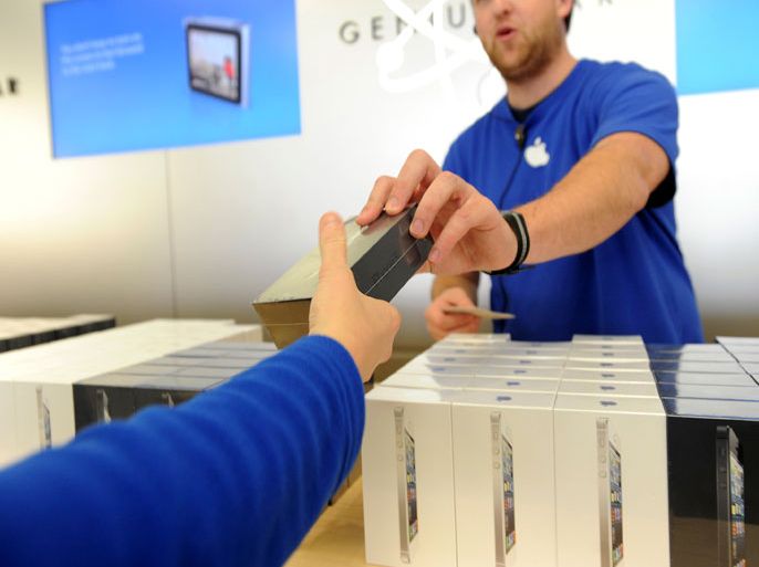An Apple employee hands out an iPhone 5 at an Apple Store in San Francisco, California, September 21, 2012. Apple fans queued around city blocks worldwide on Friday to get their hands on the new iPhone 5 - but grumbles about inaccurate maps tempered the excitement. REUTERS/Noah Berger (UNITED STATES - Tags: SCIENCE TECHNOLOGY BUSINESS TELECOMS)