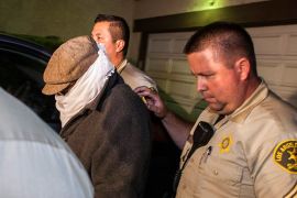 An unidentified person (L) is escorted out of Nakoula Basseley Nakoula's home by Los Angeles County Sheriff's officers in Cerritos, California September 15, 2012. Nakoula, a California man convicted of bank fraud is under investigation for possible probation violations stemming from the making of an anti-Islam video that has triggered violent protests against the U.S.in the Muslim world, U.S. officials said on Friday. The 55-year-old-man man told his Coptic Christian bishop that he was not involved in the film, but media reports have widely linked his name to the video. The obscure 13-minute English-language video, which was filmed in California and circulated on the Internet under several titles including "Innocence of Muslims," portrays Prophet Mohammad engaged in crude and offensive behavior. REUTERS