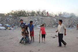 عدد من أطفال عائلة سليم يلهون في الشارع على مقربة من طرف مكب النفايات القريب من منزلهم
