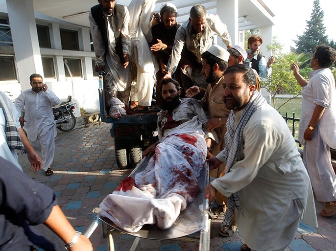 Afghan men carry a man injured in a bomb blast to a hospital in Jalalabad September 4, 2012. A suicide bomber blew himself up at a funeral in eastern Afghanistan on Tuesday, killing at least 20 people and wounding dozens, officials said, one of the biggest attacks on civilians in weeks. REUTERS