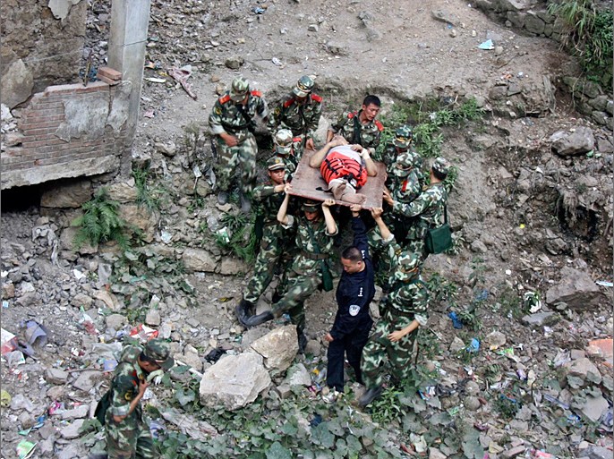 Soldiers carry an injured person with a stretcher towards safer area after two earthquakes hit Zhaotong, Yunnan province, September 7, 2012. Two shallow 5.6 magnitude earthquakes hit mountainous southwestern China on Friday, killing at least 64 people and forcing tens of thousands of people from damaged buildings, state media said. REUTERS/Stringer (CHINA - Tags: DISASTER ENVIRONMENT) CHINA OUT. NO COMMERCIAL OR EDITORIAL SALES IN CHINA