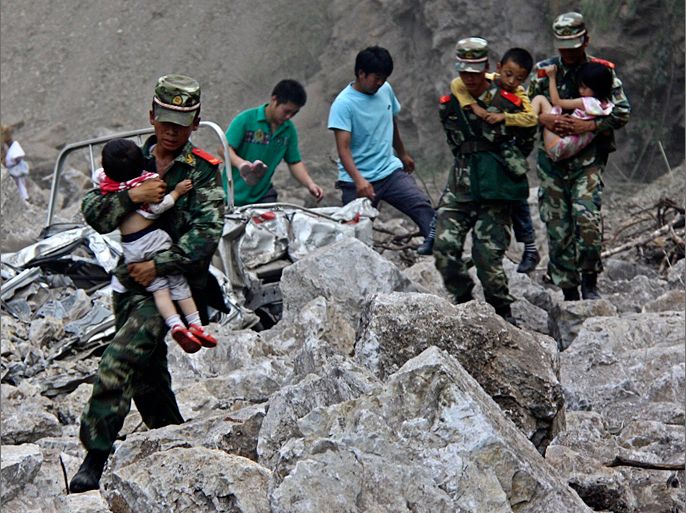 Soldiers carry children as locals follow them towards safer area after two earthquakes hit Zhaotong, Yunnan province, September 7, 2012. Two shallow 5.6 magnitude earthquakes hit mountainous southwestern China on Friday, killing at least 64 people and forcing tens of thousands of people from damaged buildings, state media said. REUTERS/Stringer (CHINA - Tags: DISASTER ENVIRONMENT) CHINA OUT. NO COMMERCIAL OR EDITORIAL SALES IN CHINA