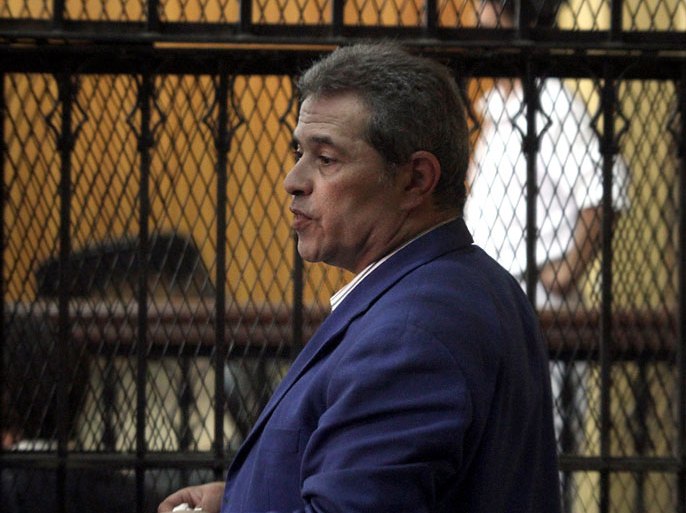 Egyptian talk show host Tawfiq Okasha stands behind bars as he attends his trial on charge of calling for the murder of President Mohamed Morsi, on September 1, 2012 in Cairo. AFP PHOTO/ AHMED MAHMUD