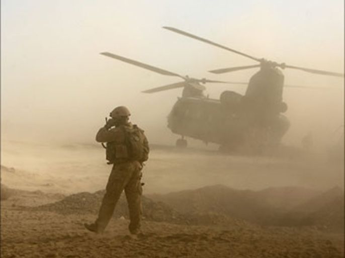 a u.s. marine talks on his radio while a chinook helicopter carrying british soldiers from b company, 2 mercian, prepares to take off in malgir, helmand province (رويترز)