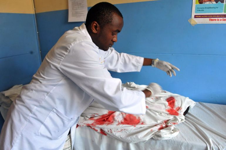 medic cover the body of a boy killed by a suspected grenade that wounded nine others in a Nairobi church on September 30, 2012, a day after Islamist fighters abandoned their last bastion in neighbouring Somalia in the face of an assault by Kenyan and other troops. The blast occurred during a service for young children at the Anglican St. Polycarp church, which lies in the Pangani district on the outskirts of the Kenyan capita