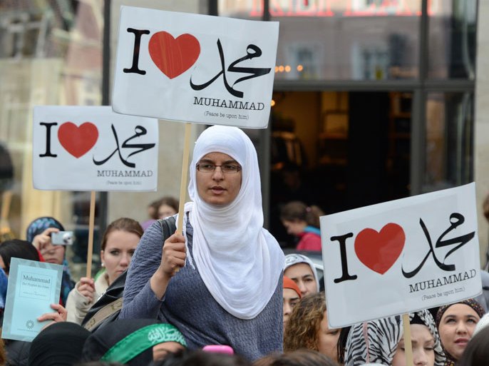 Protesters hold up signs which read "I love Mohammed" during a protest for more respect towards Muslims and Islam in Hamburg, northern Germany, September 29, 2012. Around 250 people took part in the demonstration. AFP PHOTO / DANIEL BOCKWOLDT GERMANY OUT