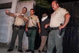 An unidentified person (2nd R) is escorted out of Nakoula Basseley Nakoula's home by Los Angeles County Sheriff's officers in Cerritos, California September 15, 2012. Nakoula, a California man convicted of bank fraud is under investigation for possible probation violations stemming from the making of an anti-Islam video that has triggered violent protests against the U.S.in the Muslim world, U.S. officials said on Friday. The 55-year-old-man man told his Coptic Christian bishop that he was not involved in the film, but media reports have widely linked his name to the video. The obscure 13-minute English-language video, which was filmed in California and circulated on the Internet under several titles including "Innocence of Muslims," portrays Prophet Mohammad engaged in crude and offensive behavior. REUTERS