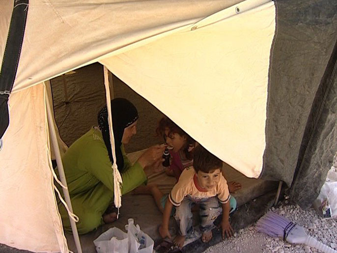 أم تعطي طفلتها دواء في مخيم الزعتري  (الجزيرة نت-أرشيف)