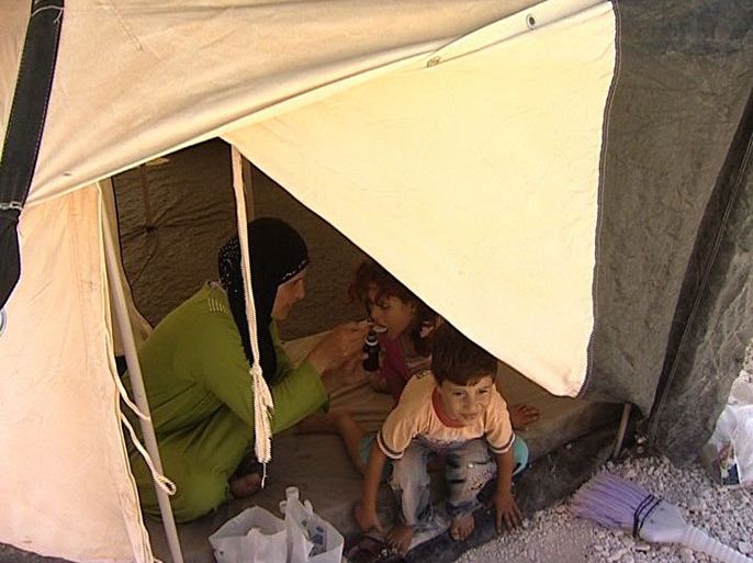 ام تعطي طفلتها دواء في مخيم الزعتري اليوم.