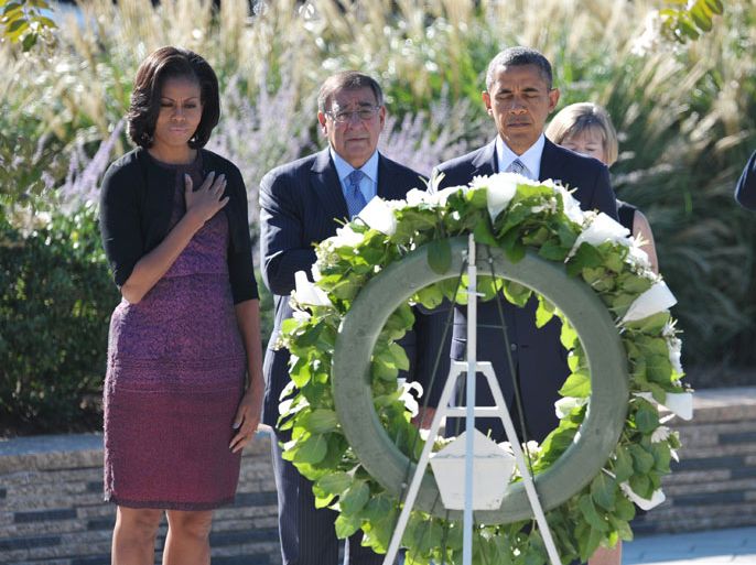 US President Barack Obama (R) , First Lady Michelle Obama (L), and Defense Secretary Leon Panetta pay their respects in front of a wreath during a ceremony commemorating the 11th anniversary of the 9/11 attacks on September 11, 2012 at the Pentagon in Washington, DC. AFP PHOTO/Mandel NGAN