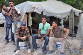 عمال من الضفة الغربية بعد انتهاء يوم العمل يجلسون قبالة خيمة اللجوء المنصوبة بسهول إحدى بلدات الداخل الفلسطيني