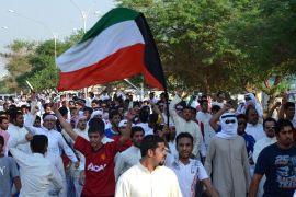 Stateless Arabs, known as bidoons, wave a Kuwaiti flag as they march during a protest to demand citizenship and other basic rights in Jahra, 50 kms (31 miles) northwest of Kuwait City, on October 2, 2012. AFP PHOTO/YASSER AL-ZAYYAT