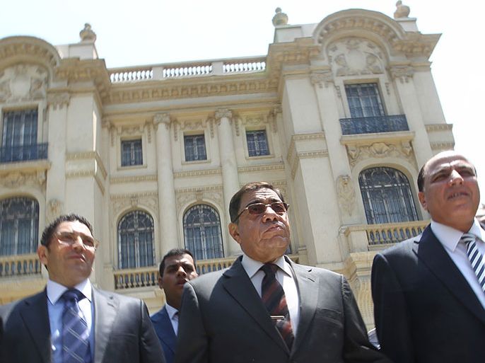 Egypt's Prosecutor General Abdel Meguid Mahmud (C) leaves after speaking to journalists following his inspection of the Mohammed Mahmoud Khalil Museum (background) in Cairo on August 22, 2010, a day after a Van Gogh painting 'Poppy Flowers' valued at more than 50 million dollars was cut out of its frame and stolen.