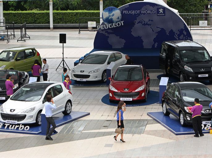 dated 11 August 2009 showing visitors walking past Peugeot cars on display at a shopping complex in Bangkok, Thailand. Thailand sold more than 1.7 million vehicles in the first nine months of this year, putting the kingdom on track to surpass the 2 million mark for the first time in one year, industry sources said 18 October 2012.