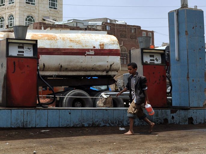 epa03300604 A Yemeni boy holding a plastic bottle filled with fuel walks past a gasoline station in Sana'a, Yemen, 08 July 2012. According to media reports, Yemen will resume next week oil exports from oil fields following a suspension that lasted for over 18 months because attacks by tribesmen and militants on a key oil pipeline, leading to four billion U.S. dollar losses. Oil exportation accounts for 75 per cent of Yemen's budget revenues, reports added. EPA/YAHYA ARHAB