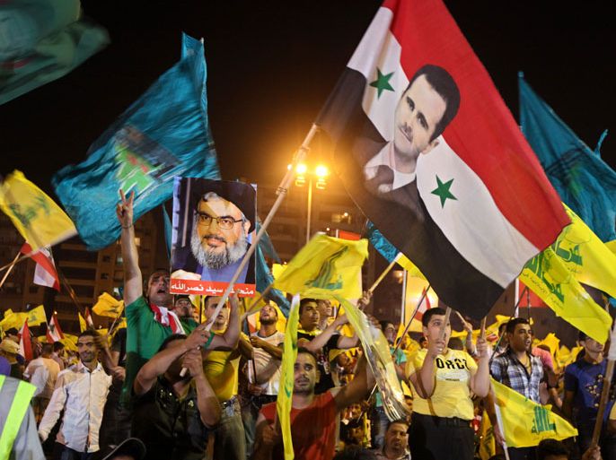 Hezbollah supporters wave Hezbollah and Syrian flags with a picture of Syrian President Bashar Assad, right, and Hezbollah leader Sheik Hassan Nasrallah, left, during a rally marking the sixth anniversary of the 2006 Israel-Hezbollah war, in Beirut's southern suburb, Lebanon, Wednesday, July 18, 2012. Nasrallah condemned an attack that killed three regime leaders in Damascus Wednesday, calling them "comrades" in the struggle against Israel. He said "the most important rockets" that Hezbollah fired on Israel in the 2006 war came from Syria.